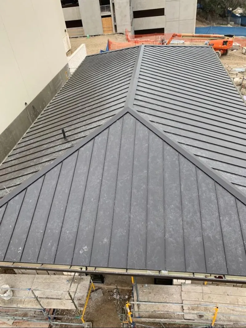 Commercial metal roof construction with crane equipment in North Fair Oaks